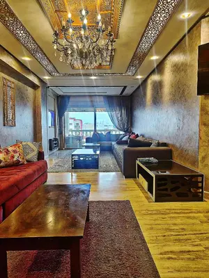a living room with a couch and a chandelier at Grande appartement 4 chambre in Casablanca