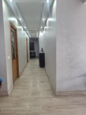 an empty hallway with white walls and a wooden floor at Grande appartement 4 chambre in Casablanca