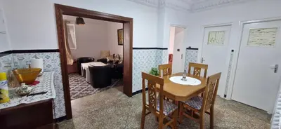 a room with a table and chairs and a living room at Appartement Océan in Rabat