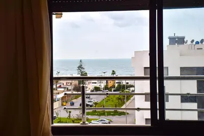 a window view of the ocean from a hotel room at Modern Apt with sea view and access to the beach in El Harhoura
