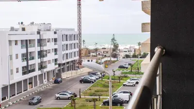 a view from a balcony of a street with cars parked at Modern Apt with sea view and access to the beach in El Harhoura