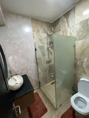 a bathroom with a shower and a toilet and a sink at Appartement à Skhirat plage in Skhirat