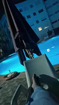 a person sitting in a chair with a laptop at apartement avec piscine résidence sécurisée meublé confort jnan dalia Boznika in O Ben Slimane
