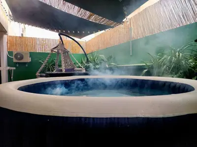 a bath tub with a fountain in a room with plants at Cozy private jacuzzi spa apartment in Casablanca