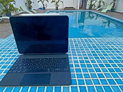 a laptop computer sitting on a table next to a swimming pool at Cozy private jacuzzi spa apartment in Casablanca