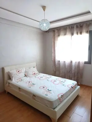 a bedroom with a bed with pink roses on it at Apartment kamal park G39 in Mohammedia