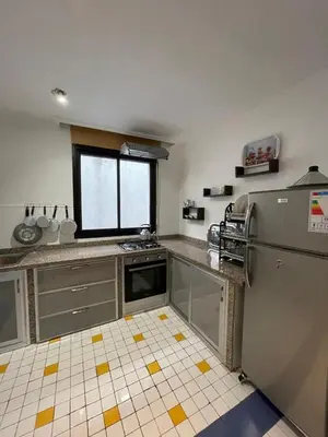 a kitchen with a refrigerator and a window at Bd les iris in Casablanca