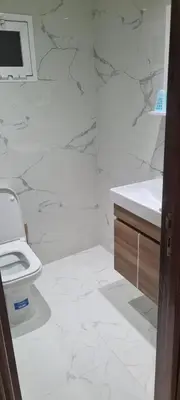 a white bathroom with a toilet and a sink at Rabat in Temara