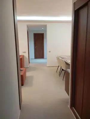 a hallway with a room with a table and a door at Ennour in Rabat
