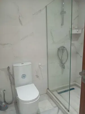 a bathroom with a toilet and a glass shower at Ennour in Rabat