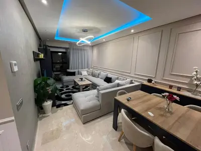 a living room with a couch and a table at Appartement dans un cadre convivial in Rabat