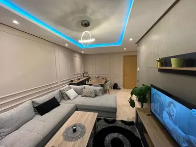 a living room with a couch and a tv at Appartement dans un cadre convivial in Rabat
