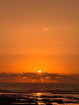 an orange sunset over the ocean with the sun setting at 2BR Beach Apt, Pool, Luxury place in Mansouria