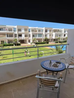 a patio with a table and chairs on a balcony at 2BR Beach Apt, Pool, Luxury place in Mansouria