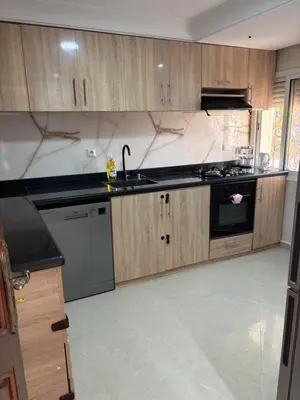a kitchen with wooden cabinets and a sink and stove at VILLA Dar BOUAZZA, Vue sur mer, 200m de la plage in Dar Bouazza