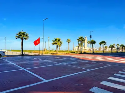 a parking lot with palm trees and a red flag at Maya Suites - Seaside Luxury Apartment in Casablanca