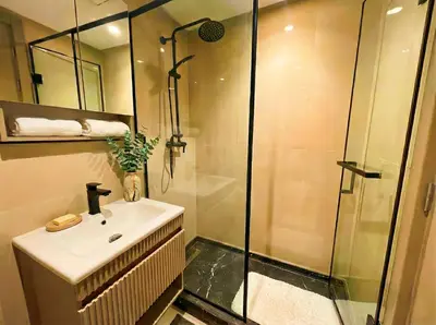 a bathroom with a sink and a glass shower at Maya Suites - Seaside Luxury Apartment in Casablanca