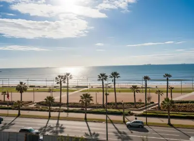 a view of the beach and the ocean from a balcony at Maya Suites - Seaside Luxury Apartment in Casablanca