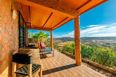 an outdoor deck with a view of the mountains at La Tulipe de Zaer - Maison de Campagne vue Montagnes - Piscine Privée