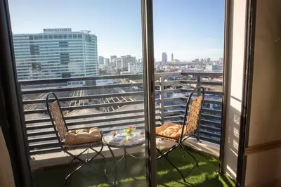 a balcony with a table and chairs and a view of a city at R109- Outstanding 1 BR Aprt with Great View in Casablanca