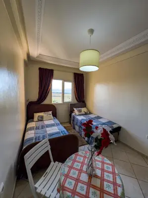 a room with two beds and a couch and a table at artisanat in Mohammedia