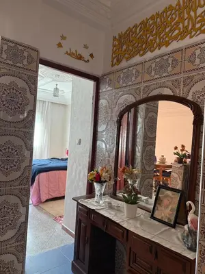a room with a mirror and a table with flowers at Appartement central à Témara, proche de Rabat in Temara
