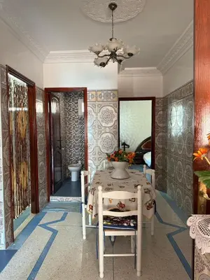 a dining room with a table and a chandelier at Appartement central à Témara, proche de Rabat in Temara