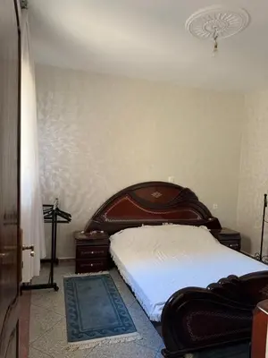 a bedroom with a bed with a wooden head board at Appartement central à Témara, proche de Rabat in Temara