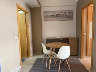 a dining room with a table and two white chairs at Cozy Downtown Apartment - Casa Port TGV in Casablanca