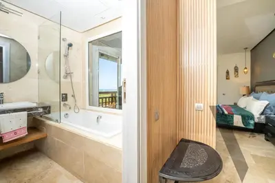 a bathroom with a tub and a sink and a bed at Seaside Luxury 3BR With Pool & Private Beach Access in Bouznika