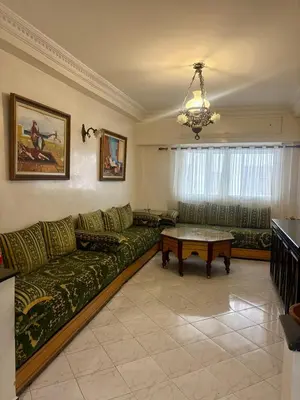 a living room with a green couch and a table at Appartement en plein cœur de Agdal in Rabat