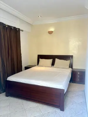a bedroom with a large bed with white sheets at Appartement en plein cœur de Agdal in Rabat