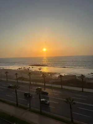 a sunset over the ocean and a highway at Appartement vue sur mer 3 chambres in Rabat