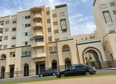 two cars parked in front of a building at Appartement vue sur mer 3 chambres in Rabat