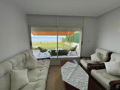 a living room with a couch and a large window at Maison Bord de Mer Skhirate in Skhirat