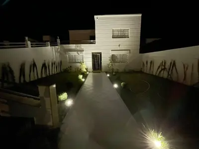 a building with lights on the side of it at night at Maison Bord de Mer Skhirate in Skhirat