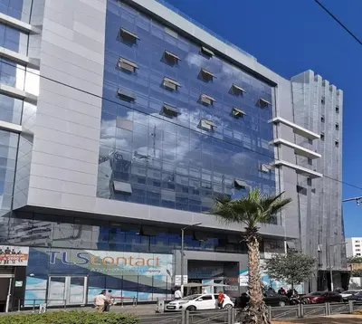 a tall glass building with a palm tree in front of it at Cozy & Bright, Free Parking, Tram in Casablanca