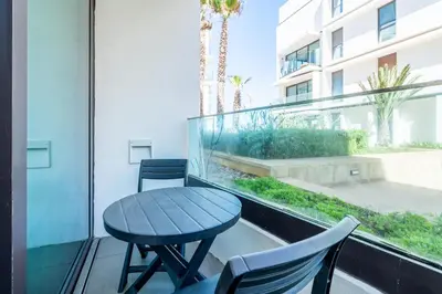 a table and chairs on a balcony with a window at C08- Anfa Place Luxury Apartment - Beach Access in Casablanca