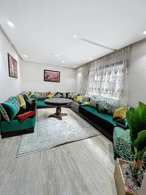 a living room with a green couch and a table at Appartement Typique Marocain in Oulad Akkou