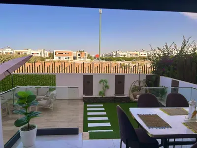 a view of a patio with a table and chairs at Appartement chic a 5 mins de la plage in El Harhoura