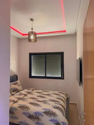 a bedroom with a bed and a window at Appartement chic a 5 mins de la plage in El Harhoura