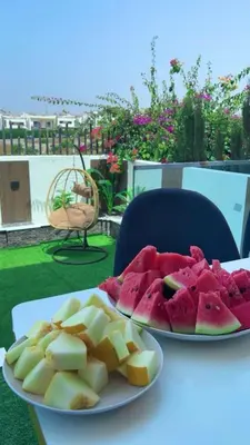 a plate of watermelons and a plate of fruit on a table at Appartement chic a 5 mins de la plage in El Harhoura