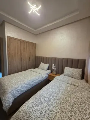 a bedroom with two beds and a light on the ceiling at Appartement in Casablanca