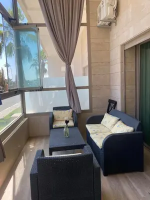 a living room with two chairs and a couch at New ground floor apartment - Large terrace direct access to pool in Bouznika