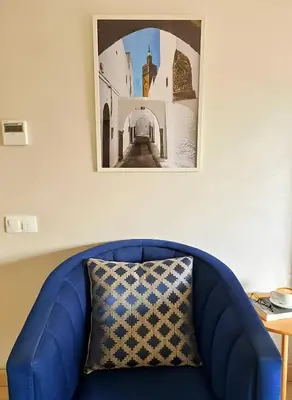 a blue couch with a pillow in a room at Maya Suites - Riviera B Casablanca in Casablanca