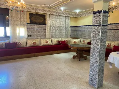 a living room with a red couch and a table at Naima in Rabat