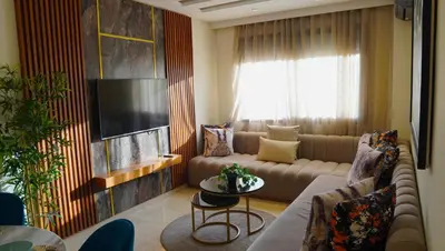 a living room with a couch and a tv at Modern Studio with Rooftop Pool & Free Parking in Casablanca