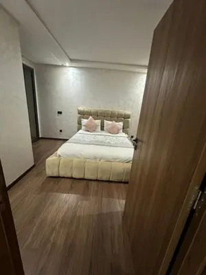 a bedroom with a bed with two pink pillows at Appartement à louer Eden Mansouria Residence in Mansouria