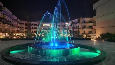 a fountain with blue and green lights in front of a building at Appartement à louer Eden Mansouria Residence in Mansouria