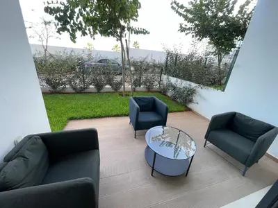 a patio with couches and a table and chairs at Appartement Steps from Anfa Park Fanzone in Casablanca
